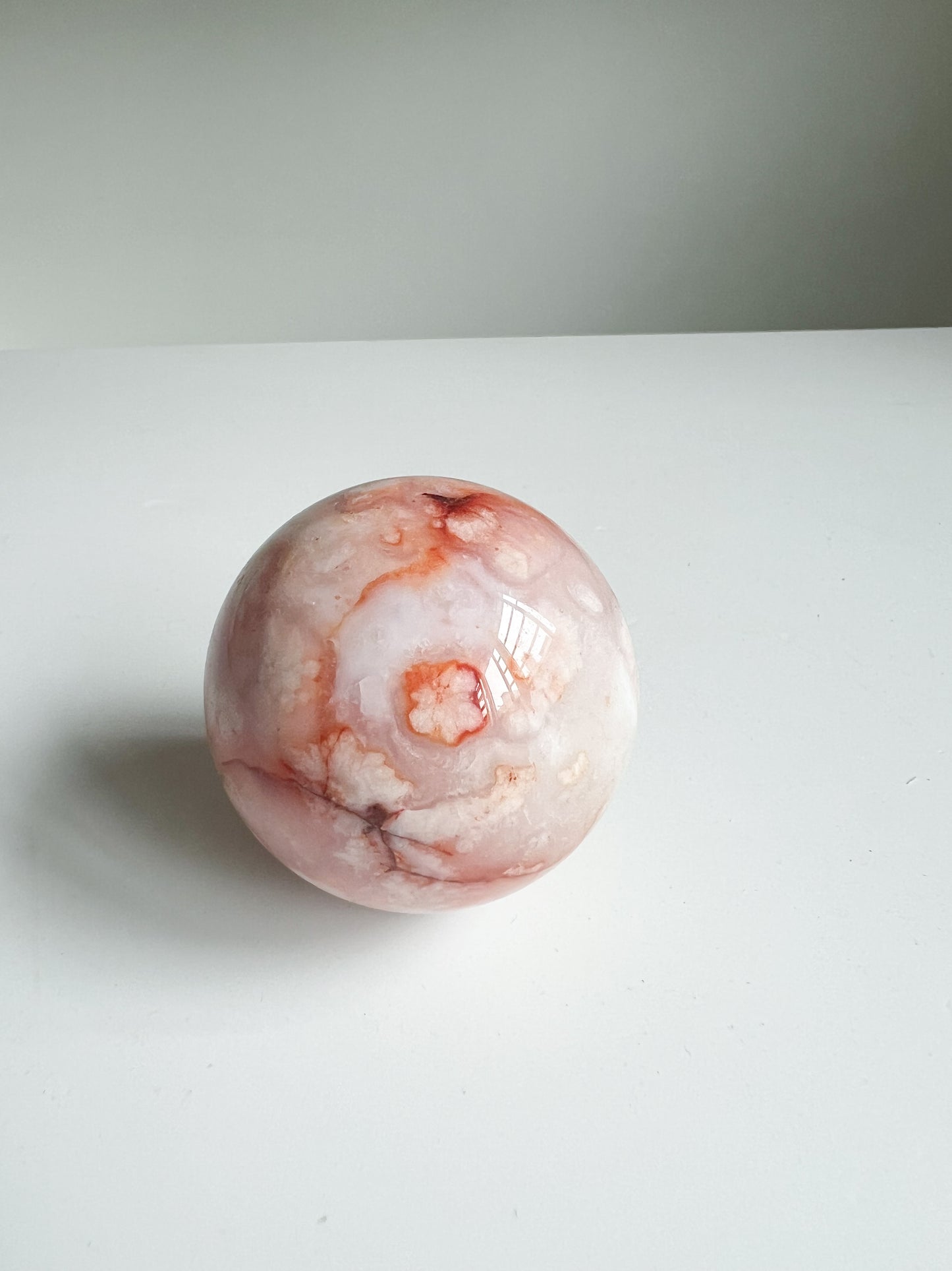 Carnelian Flower Agate sphere with peachy floral plume and coral blush patterns