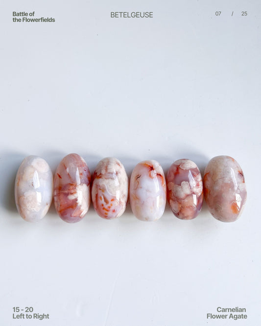 Top view of Carnelian Flower Agate beans (15–20) in pastel palette with vivid floral plumes – arranged left to right