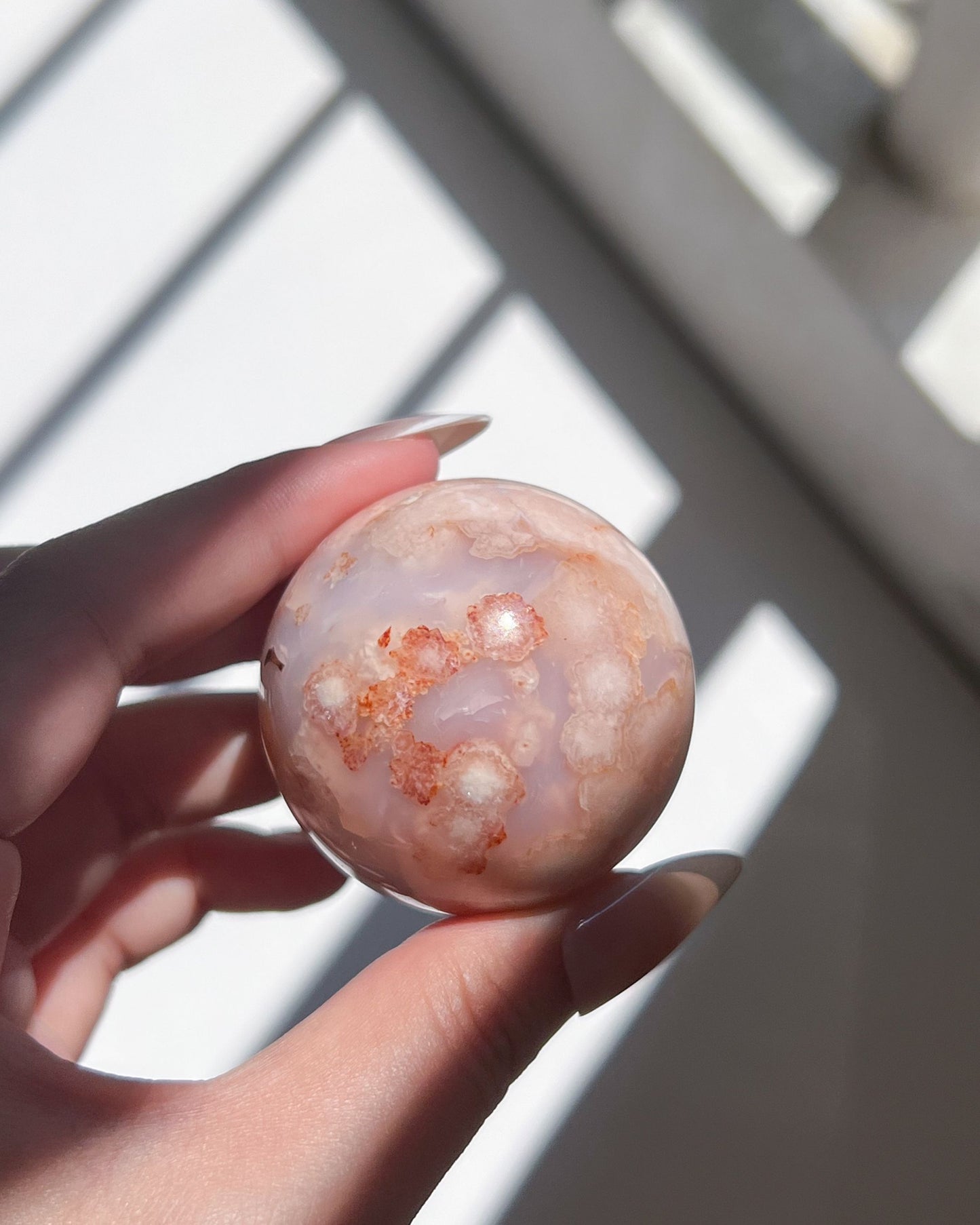 Close-up of Ume sphere’s side with deep blush coral plumes and soft translucency.
