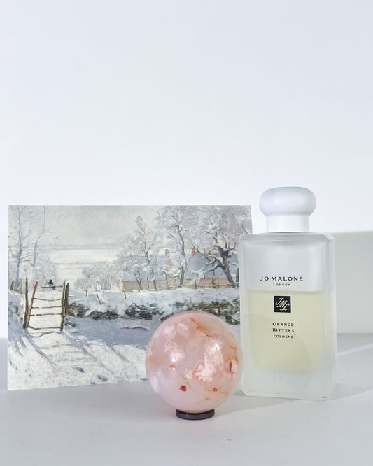 Sphere beside a Jo Malone bottle and artwork, highlighting Hana’s frosted translucency and pale peach tones.