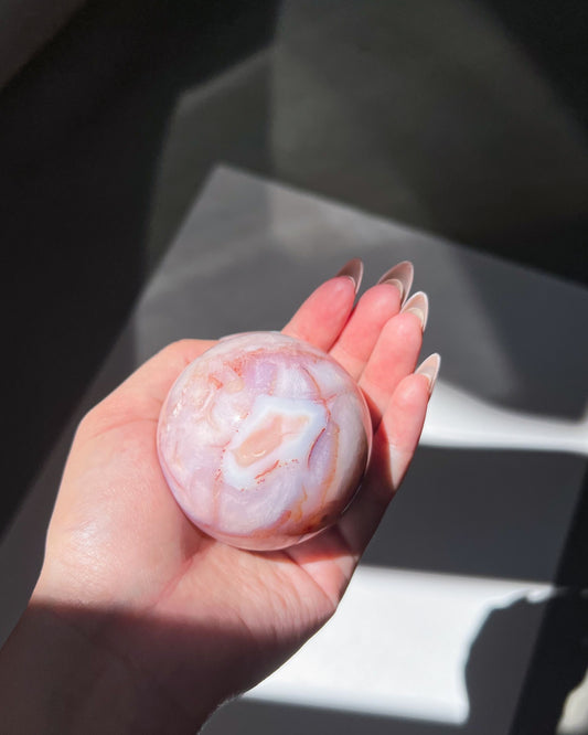 Claude held in hand with full view of lilac swirls and faint cream florals in natural light.