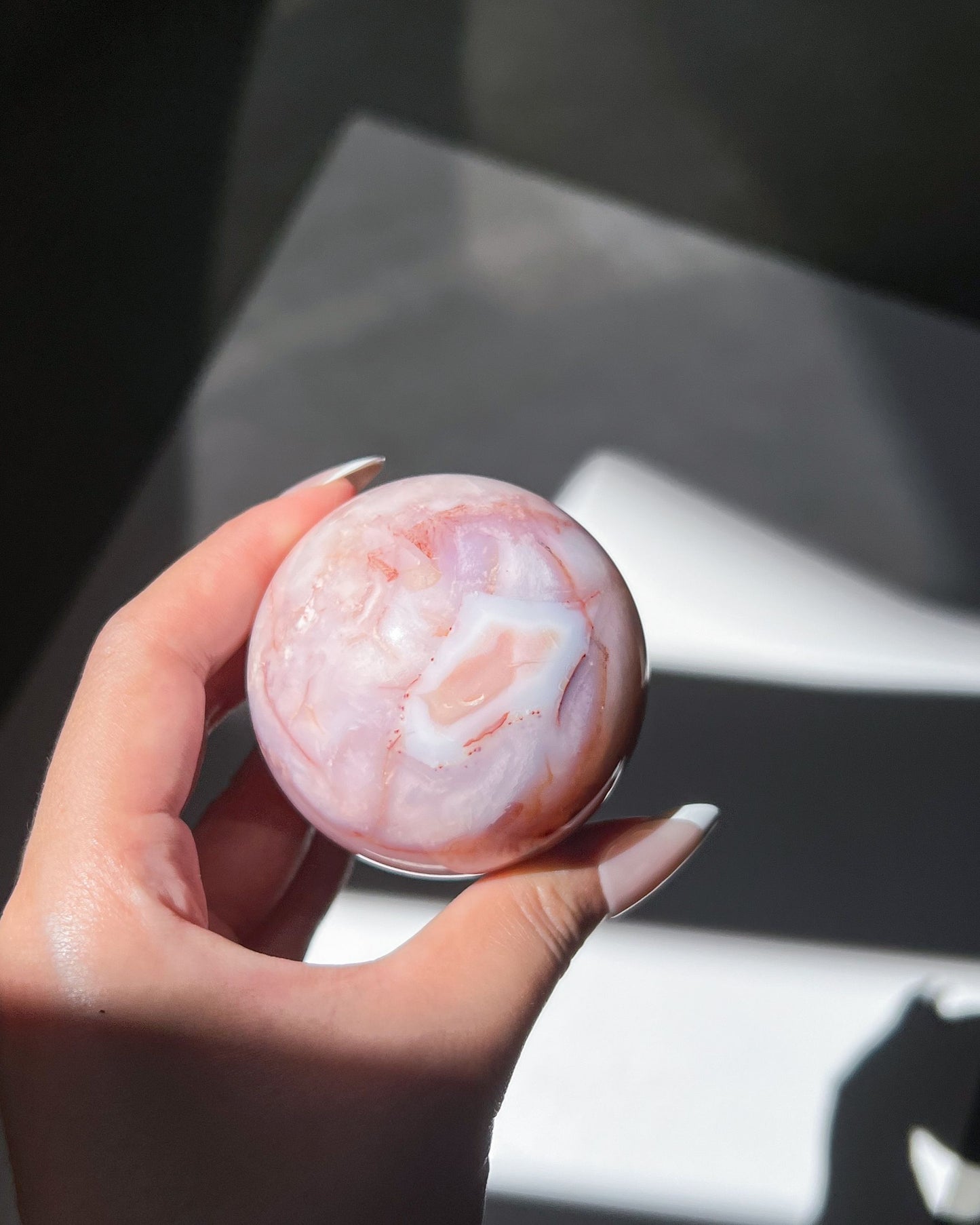 Handheld shot of Claude showing soft blush gradients and diffused lavender inclusions.