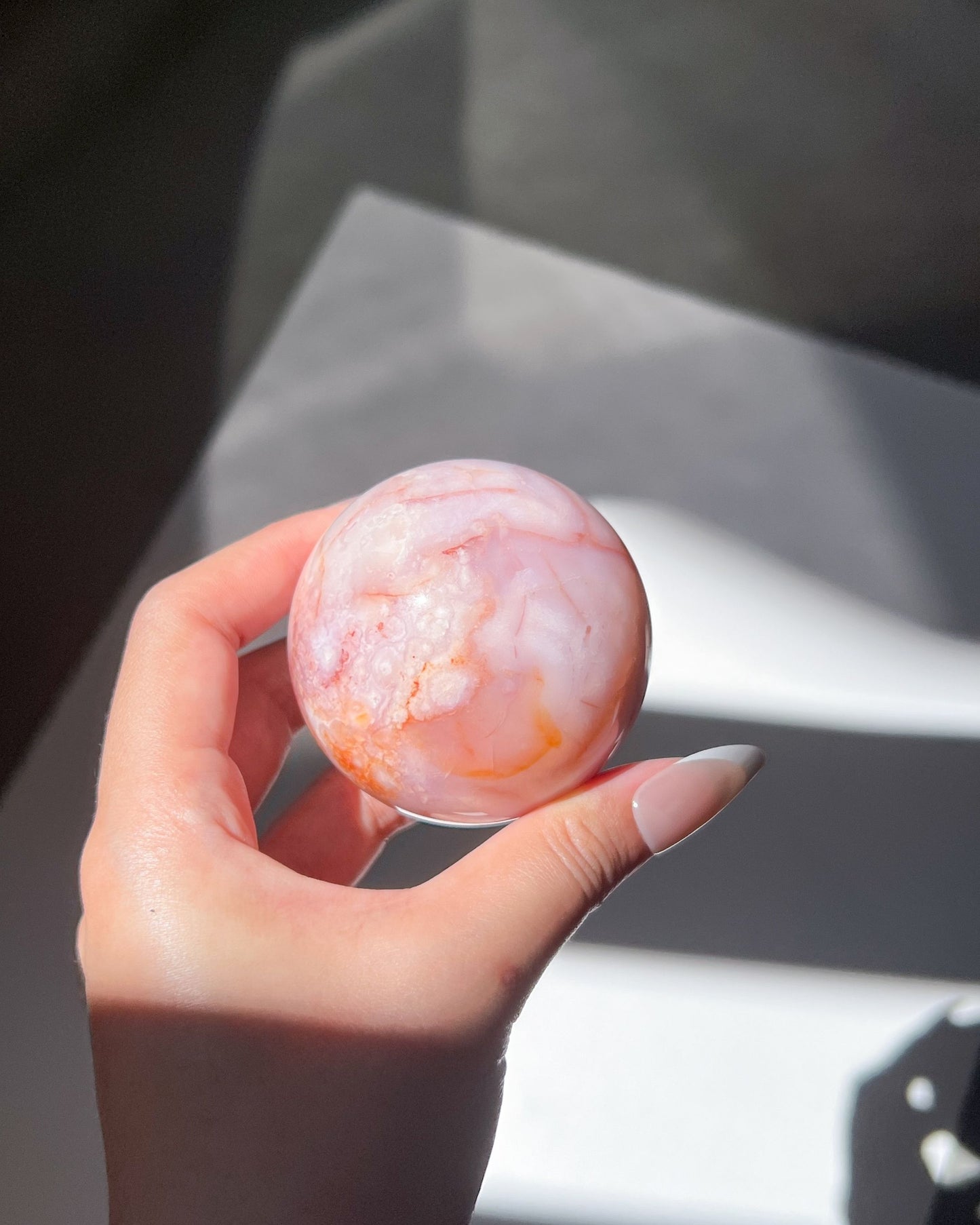 Subtle orange and white layering over translucent lilac base, handheld close-up.