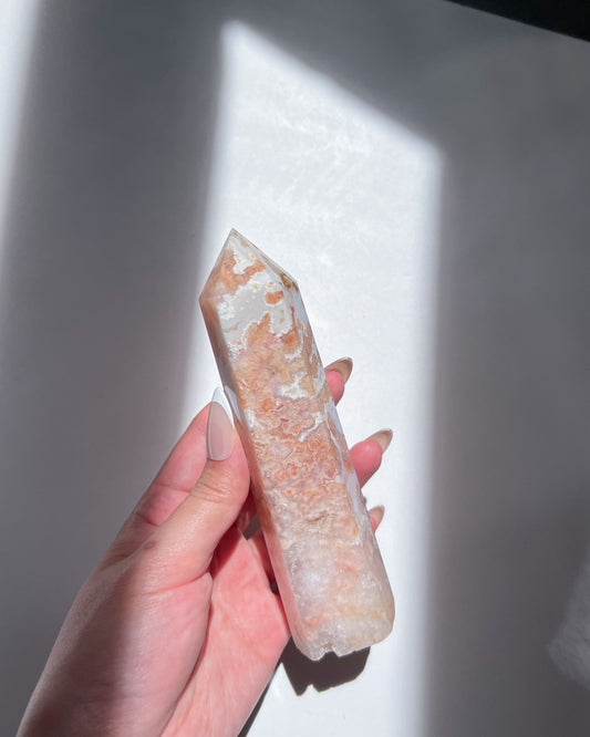 The other side of the tower showing vivid coral blossoms and white marbling against translucent crystal.