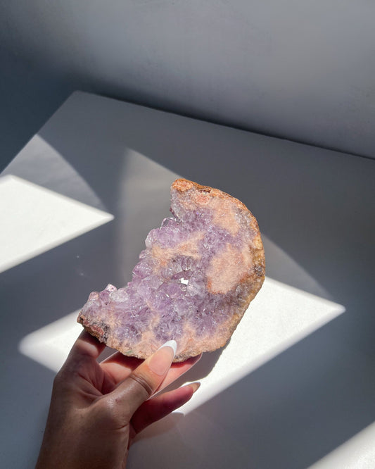 Flipside of Amethyst Flower Agate moon in hand showing glistening crystal formations