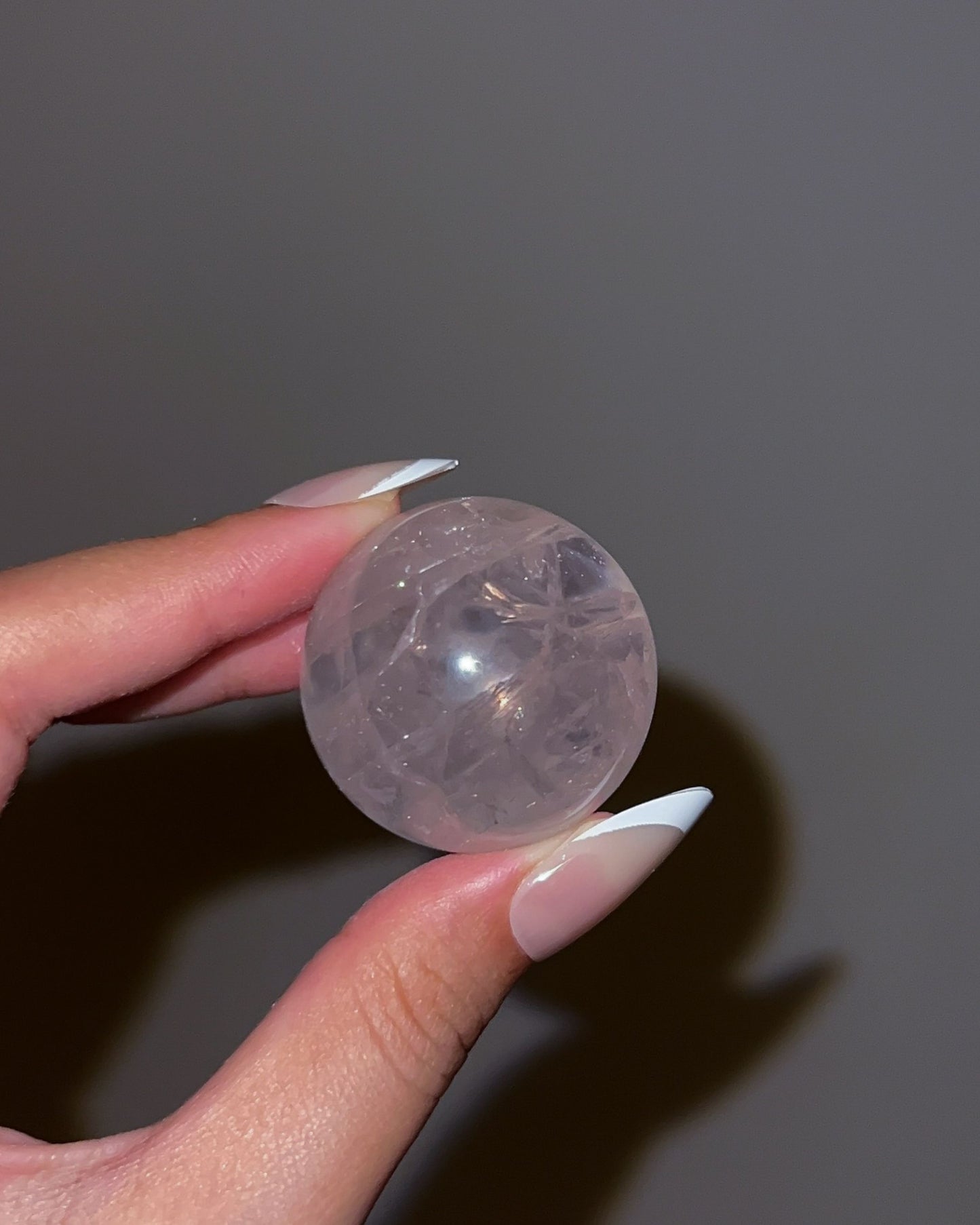 Close-up of Girasol Rose Quartz Sphere I with flash, highlighting central clarity and glowy sheen