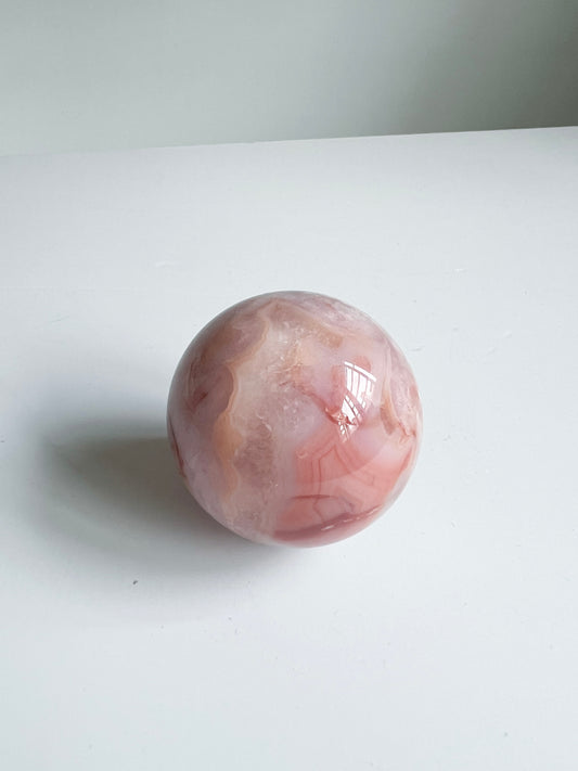 Carnelian Flower Agate sphere with peachy swirls and soft translucency — vibrant, calming, and full of inner joy.