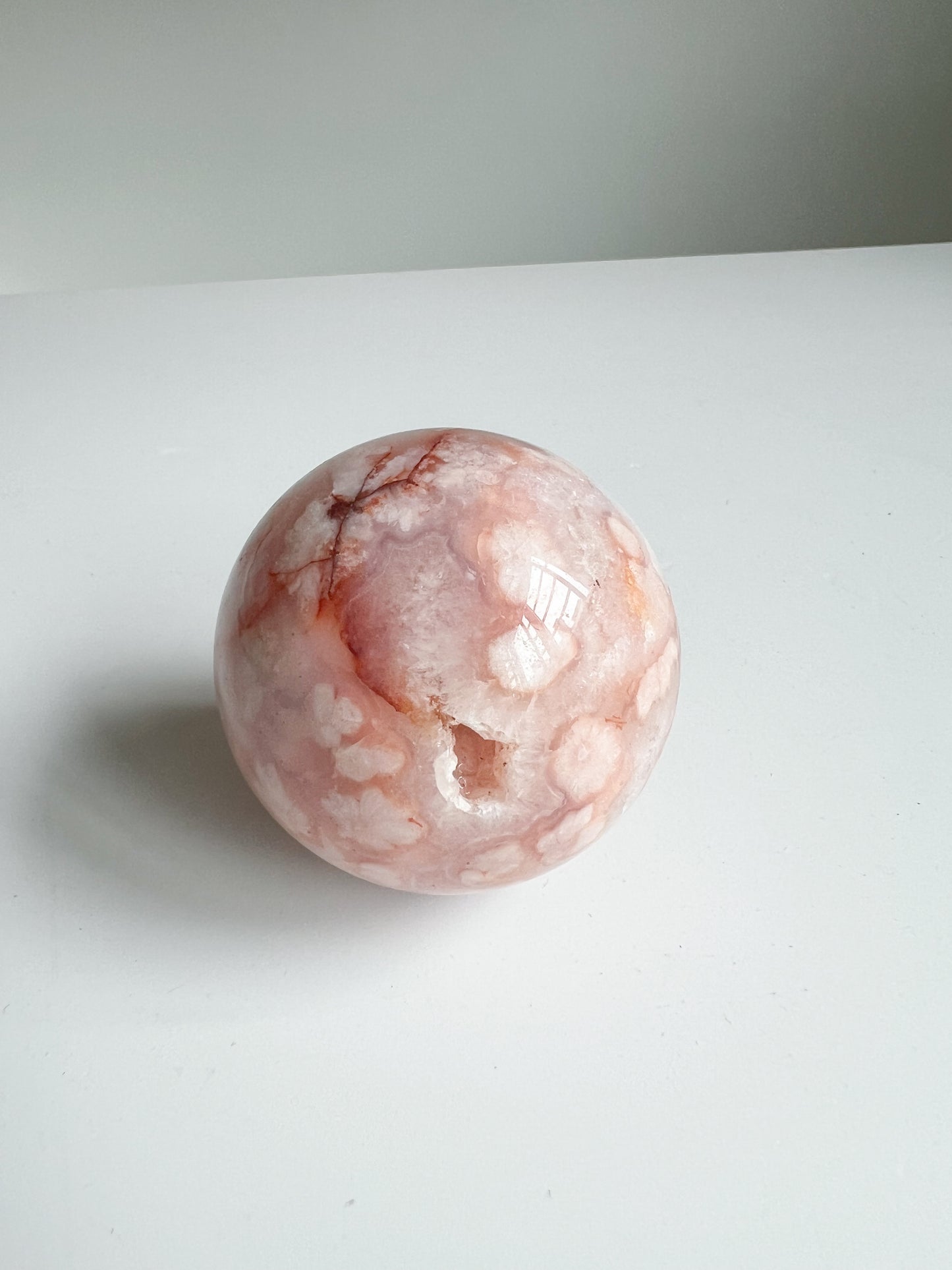 Carnelian Flower Agate sphere with a raw druzy pocket and intricate flower-like inclusions and branch