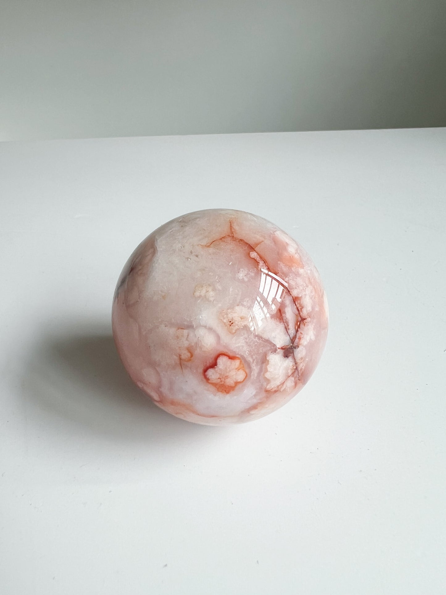 Sphere showing soft floral patterns with vivid orange veining and earthy grounding lines