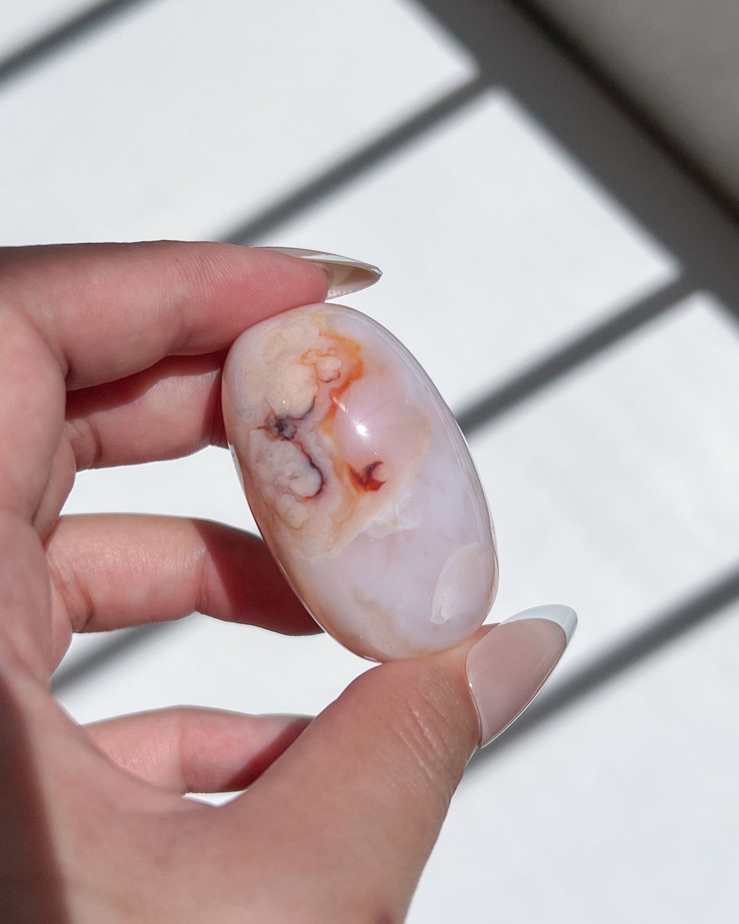 Creamy lilac-toned Carnelian Flower Agate bean with orange-red inclusions and botanical plumes
