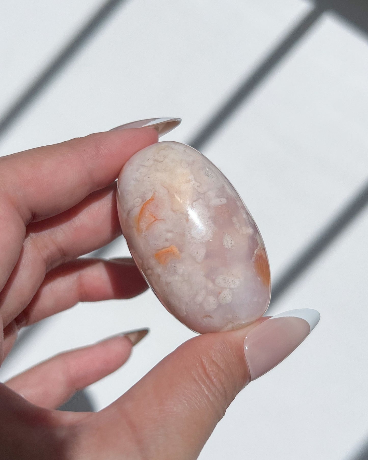 Pale and peachy Carnelian Flower Agate bean with speckled plumes and soft translucency