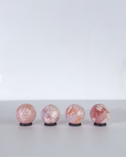 Rear view of Carnelian Flower Agate spheres revealing cloudy banding and delicate plume patterns in soft natural tones