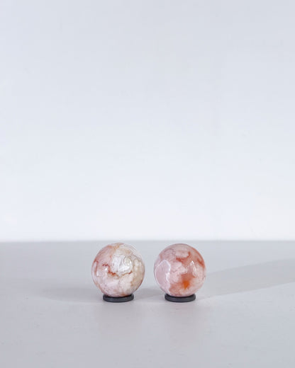 Top-down view revealing the organic floral-like textures of both Carnelian Flower Agate spheres.