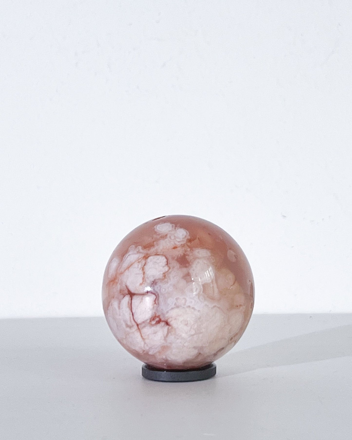 Right side of Sphere 11 showing dense creamy plumes with subtle streaks and light play on its polished surface

