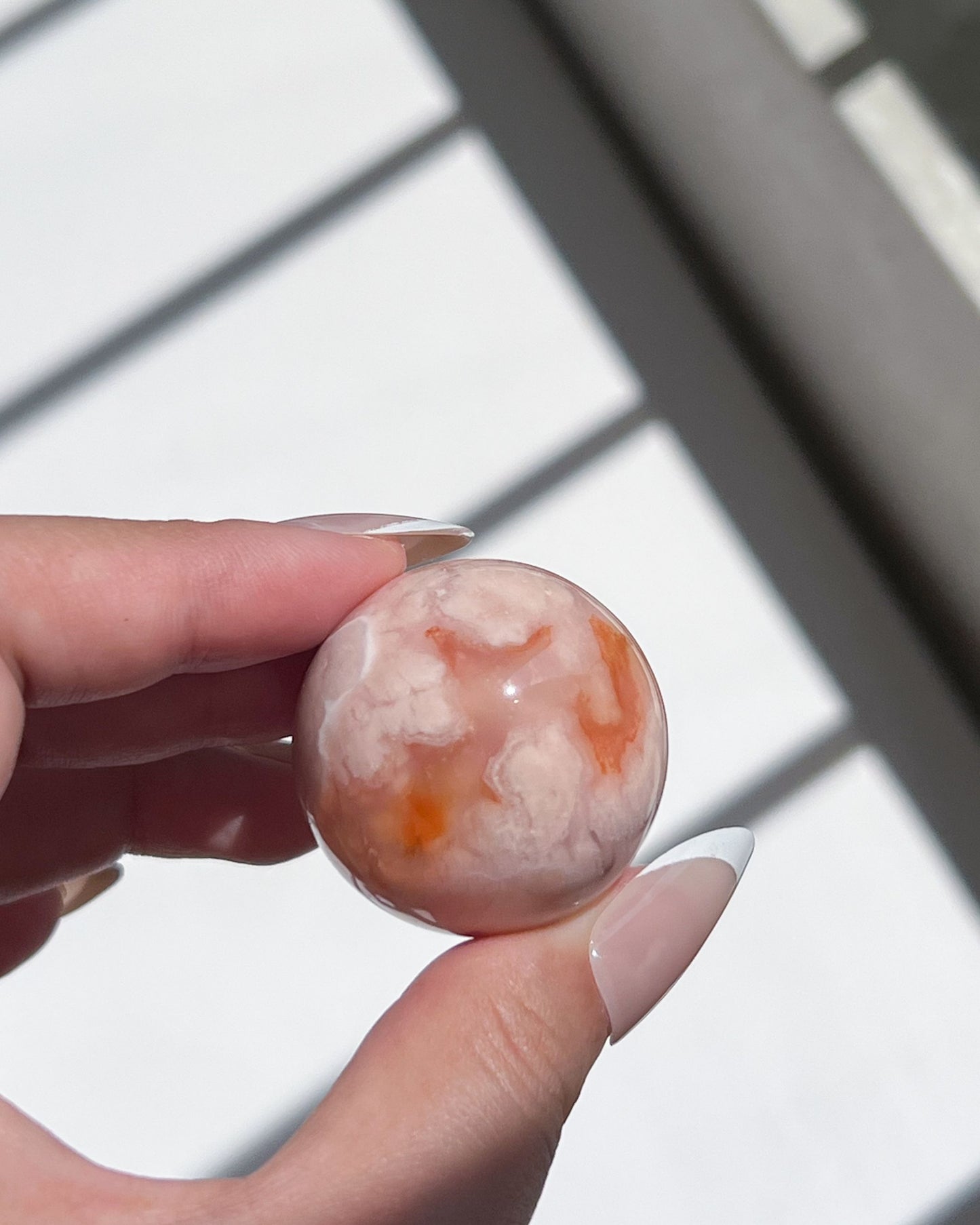 Detailed shot of sphere 09 with vibrant carnelian glow against a dreamy pink-beige base.