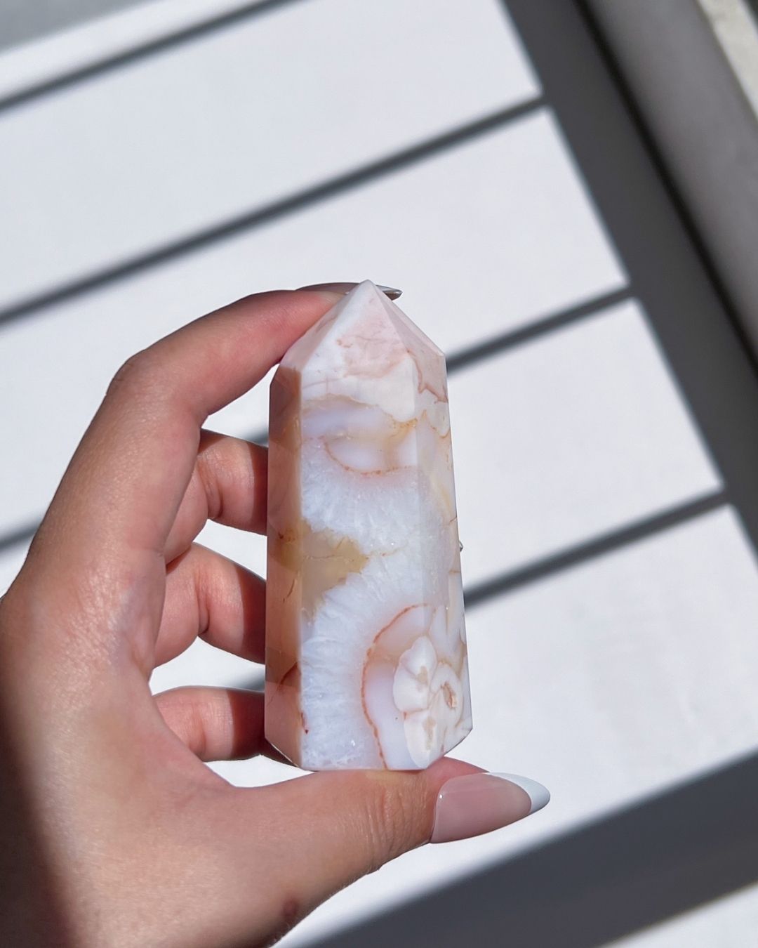 Hand holding the tower upright, highlighting subtle orange inclusions