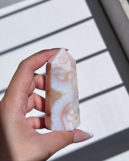 Hand holding the tower upright, highlighting subtle orange inclusions