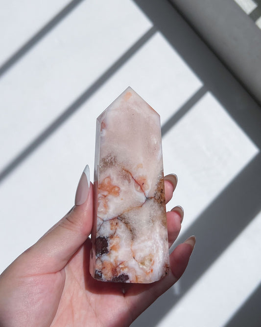 Hand holding Carnelian Flower Agate tower with warm terracotta and cream banding
