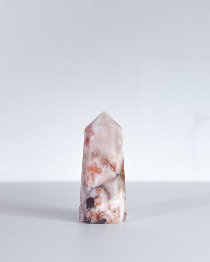 Product shot of Carnelian Flower Agate tower standing upright against white background