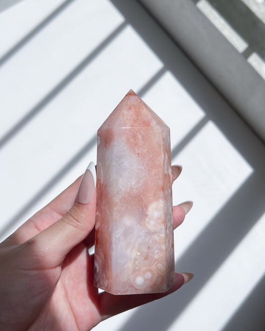 Hand holding tall Carnelian Flower Agate tower with soft pastel gradients