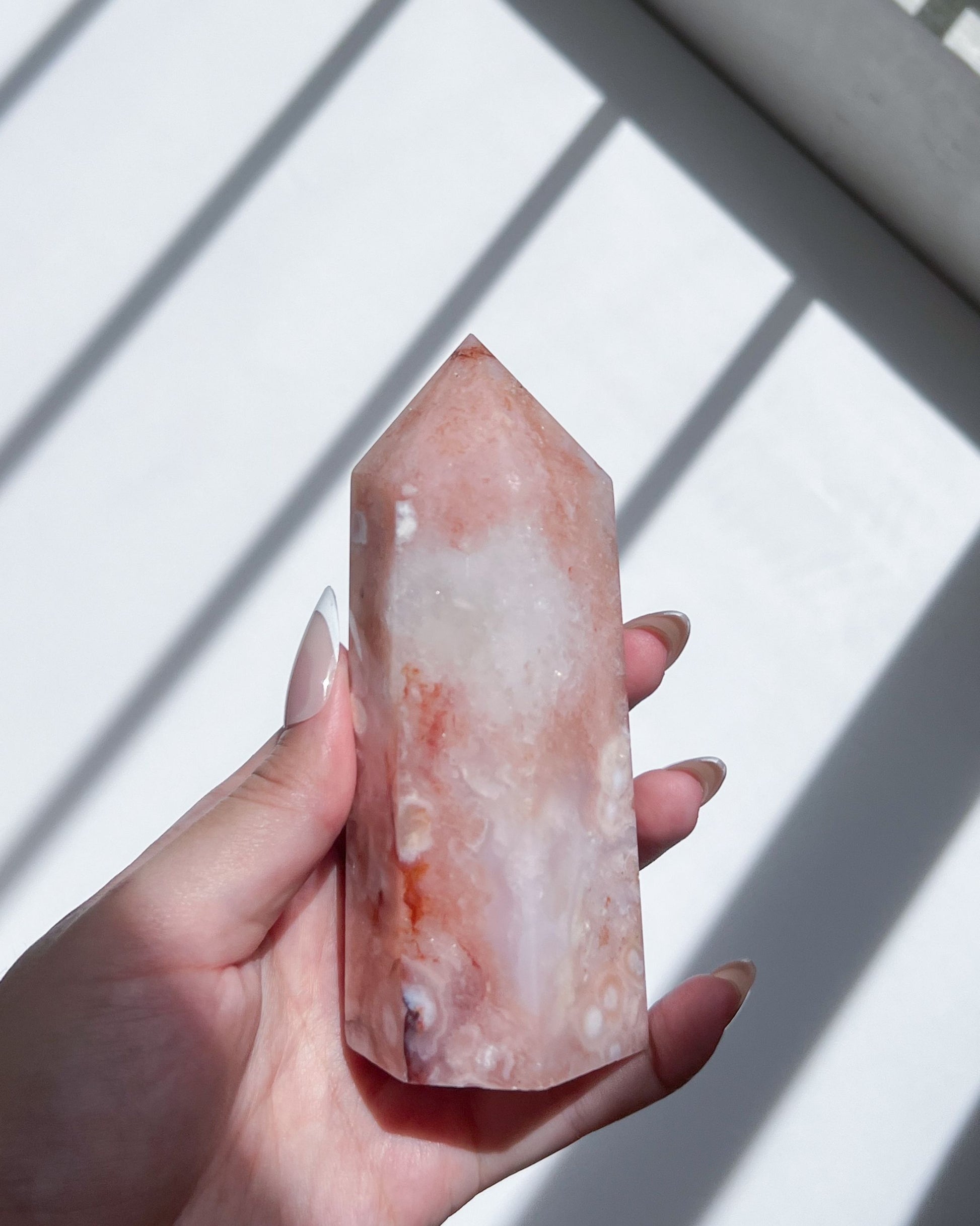 Angled handheld shot of the carnelian flower agate, highlighting the heart-shaped spot and mist-like swirls