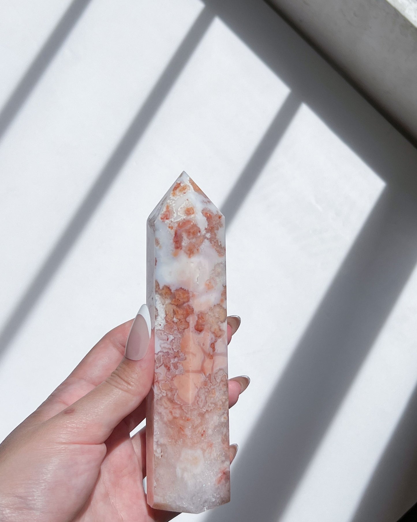 Handheld shot in natural sunlight, revealing petal-like formations and internal shimmer.