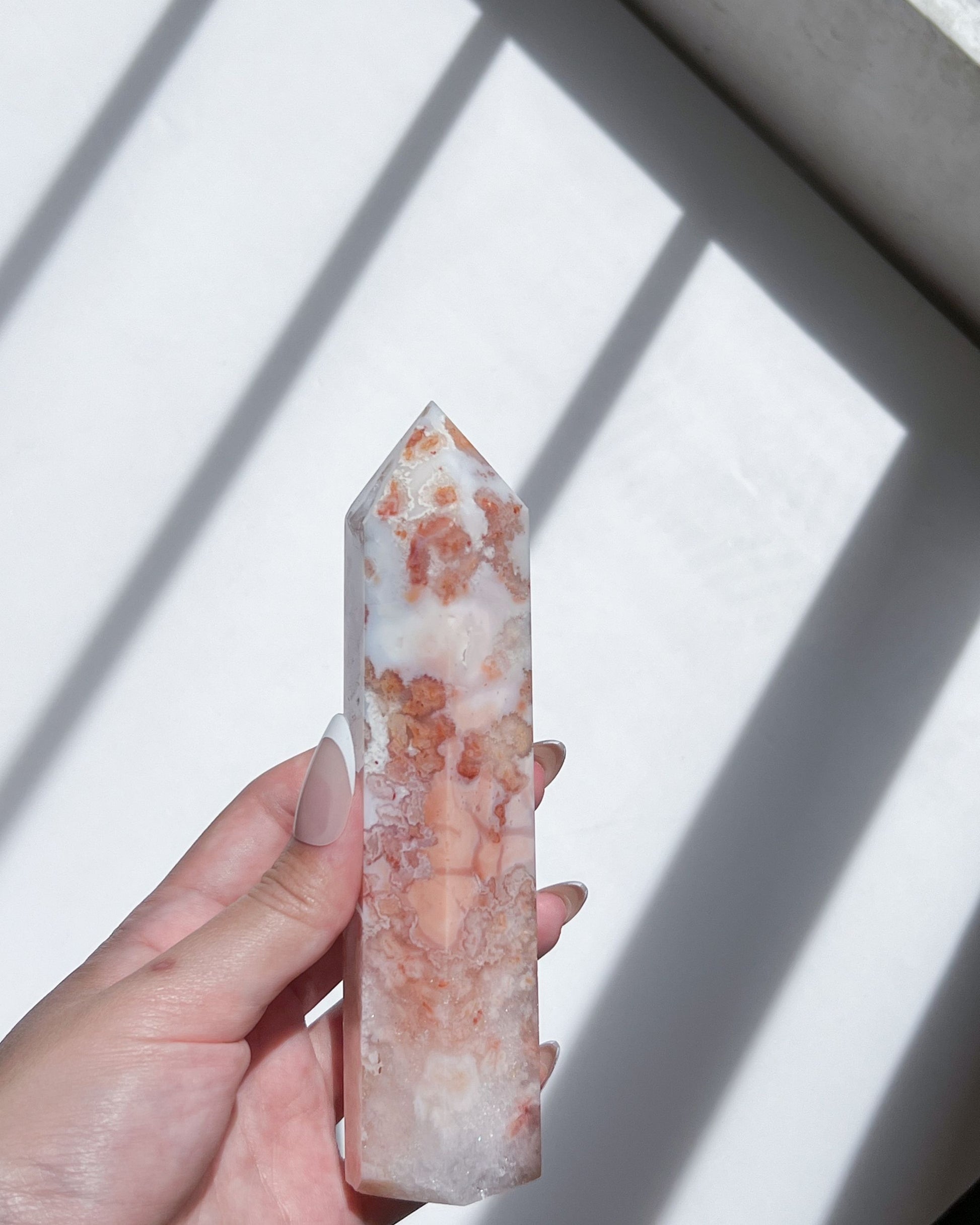 Handheld shot in natural sunlight, revealing petal-like formations and internal shimmer.