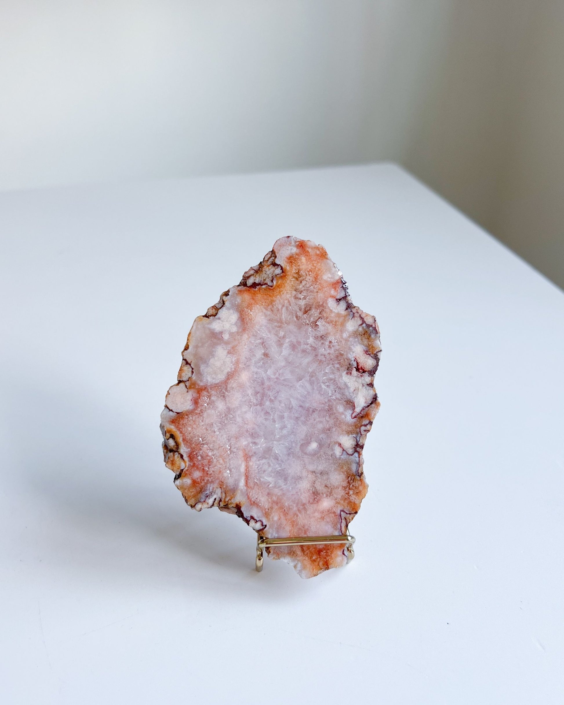 Ella slab standing upright with uneven edges and glowing peach undertones