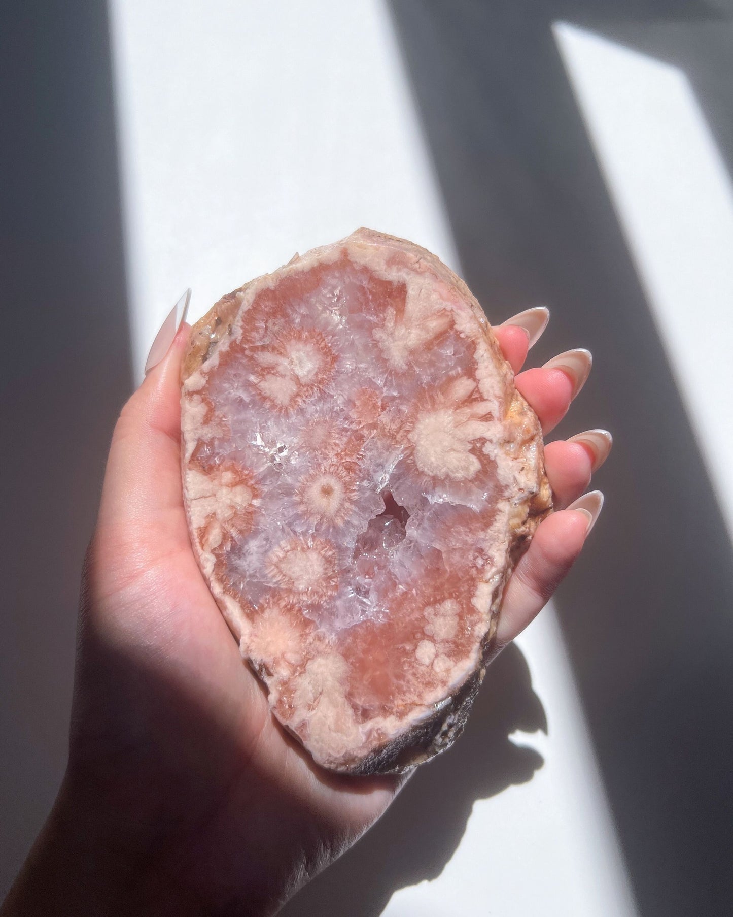 Close-up of Juliette Flower Agate showcasing inner floral plumes and mauve crystal bed
