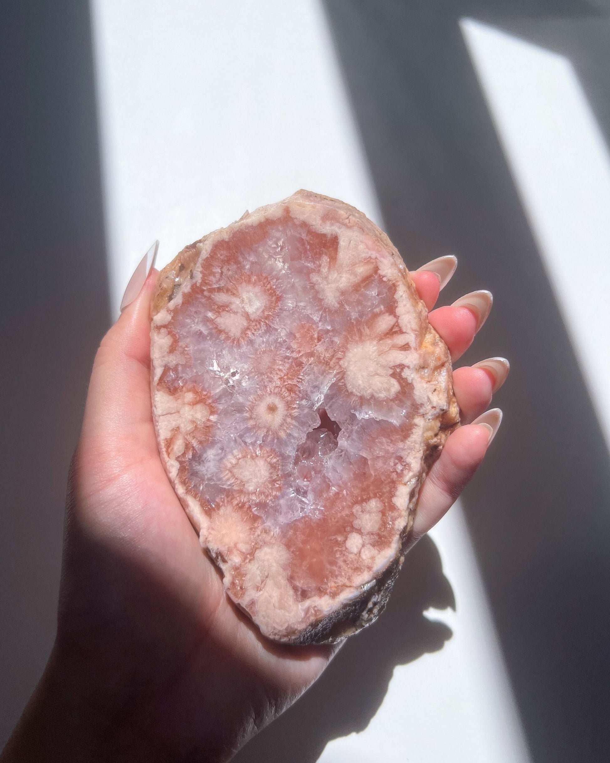 Close-up of Juliette Flower Agate showcasing inner floral plumes and mauve crystal bed
