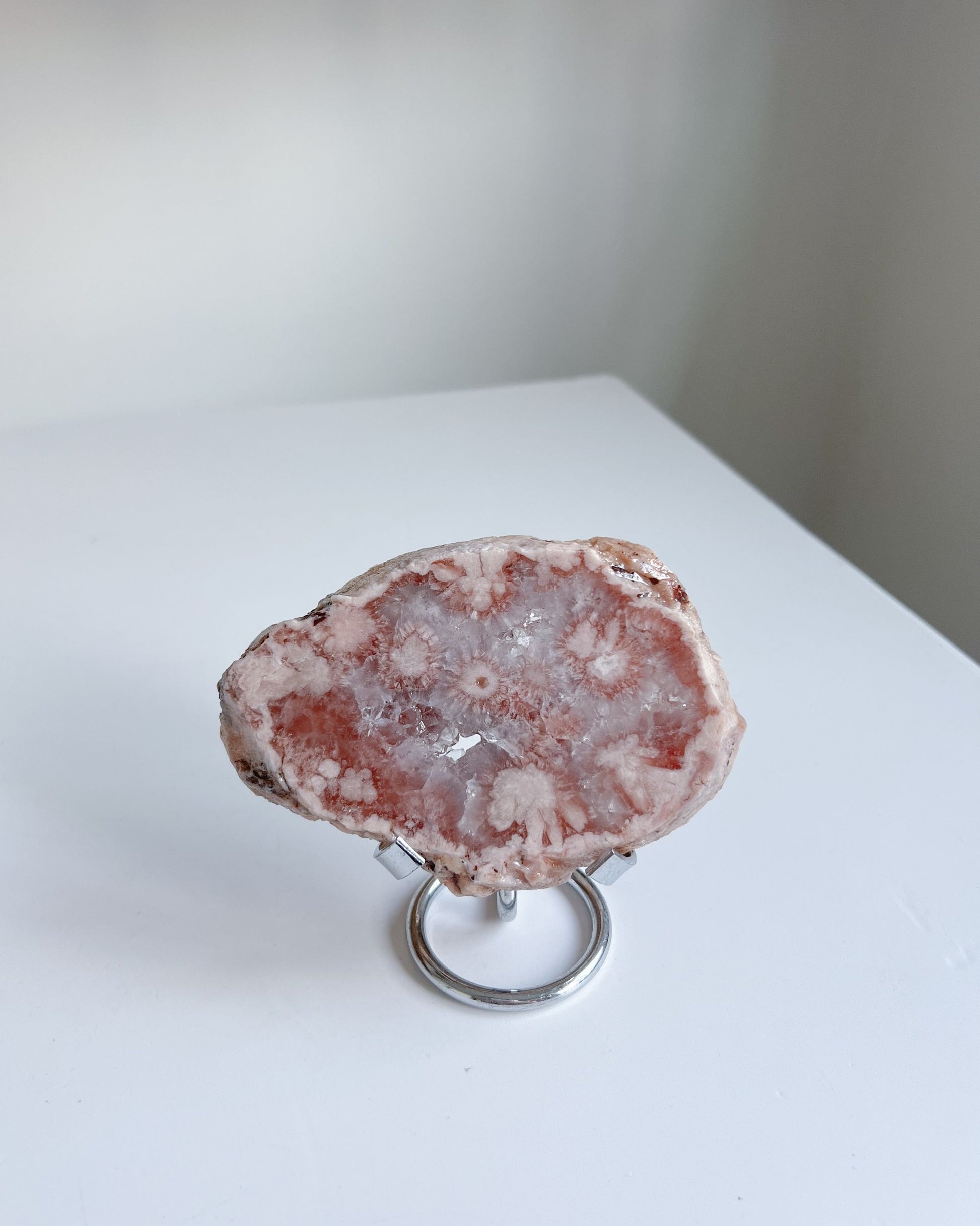 Juliette Flower Agate upright on metal stand in minimal daylight setting