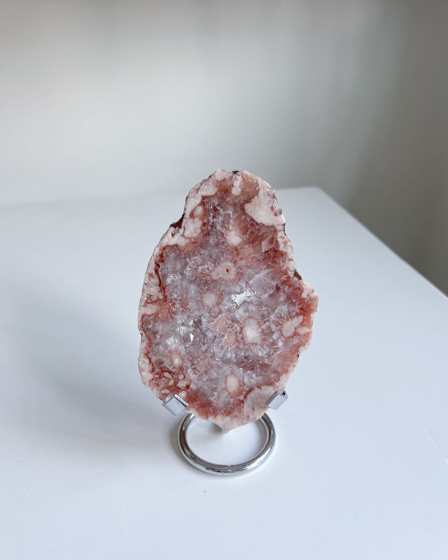 Pink crystal on a stand against a white background