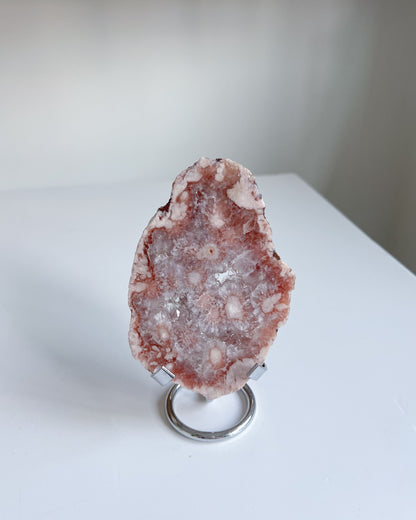 Pink crystal on a stand against a white background