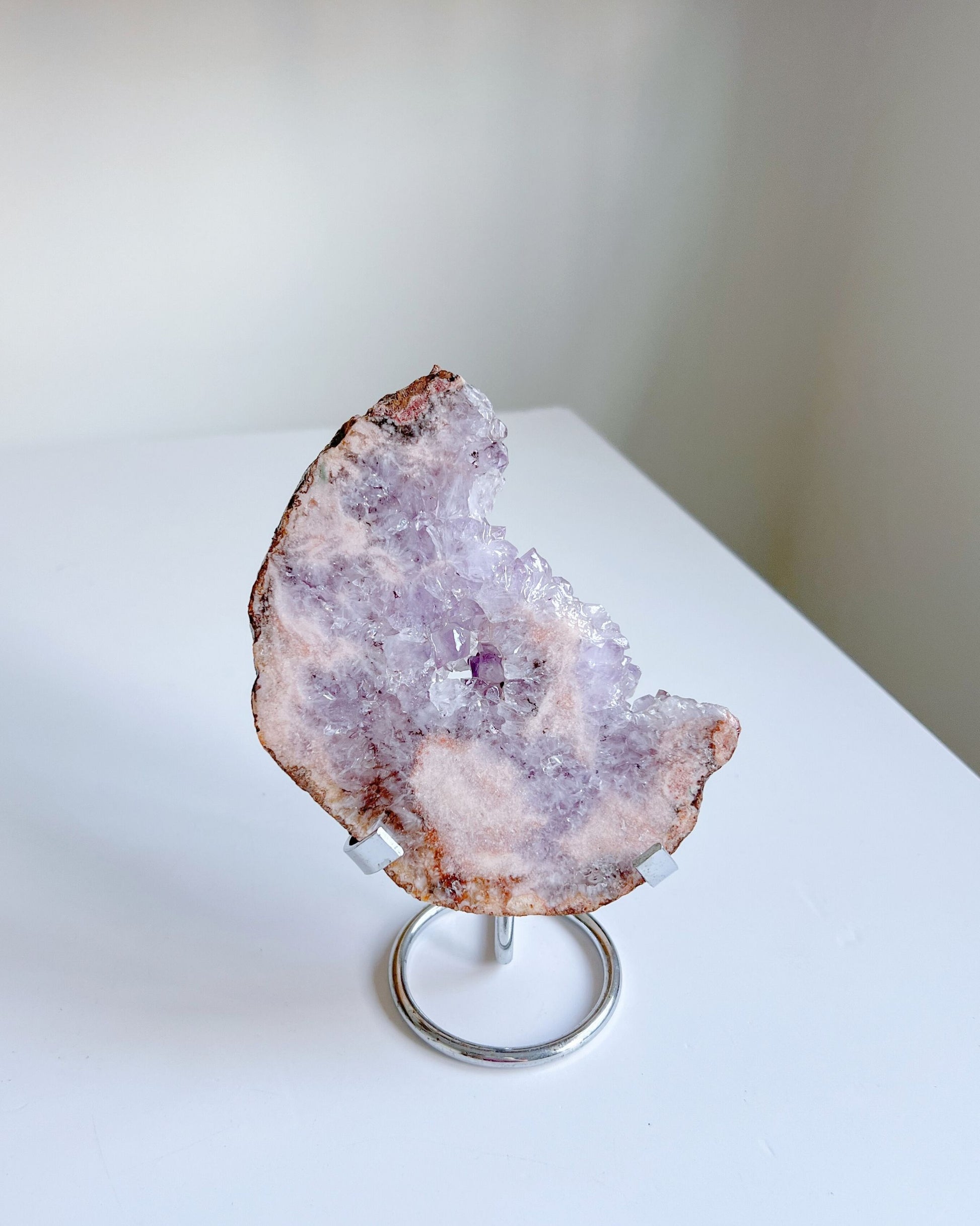 Luna Flower Agate displayed on a silver metal stand in bright daylight