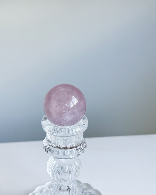 Girasol Rose Quartz sphere G with dreamy mauve pink glow on crystal stand in natural daylight