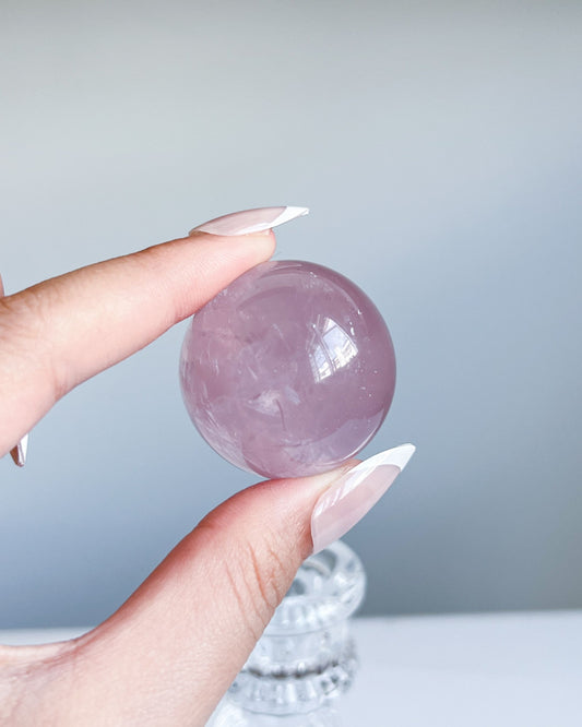 Translucent Girasol Rose Quartz sphere G showing internal misty swirls and soft window reflection