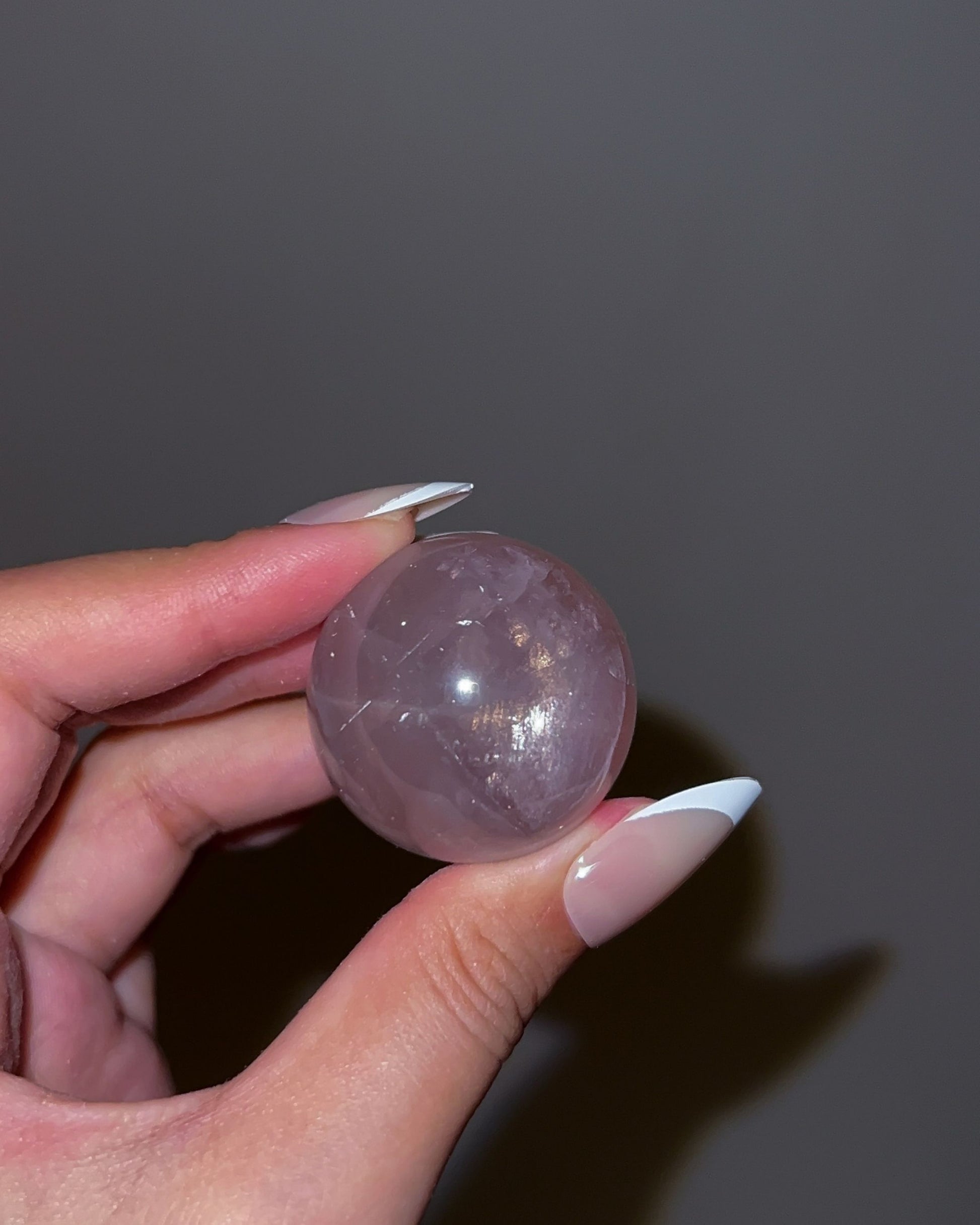 Soft violet-pink Girasol Rose Quartz sphere G captured under flash with star and wispy white banding