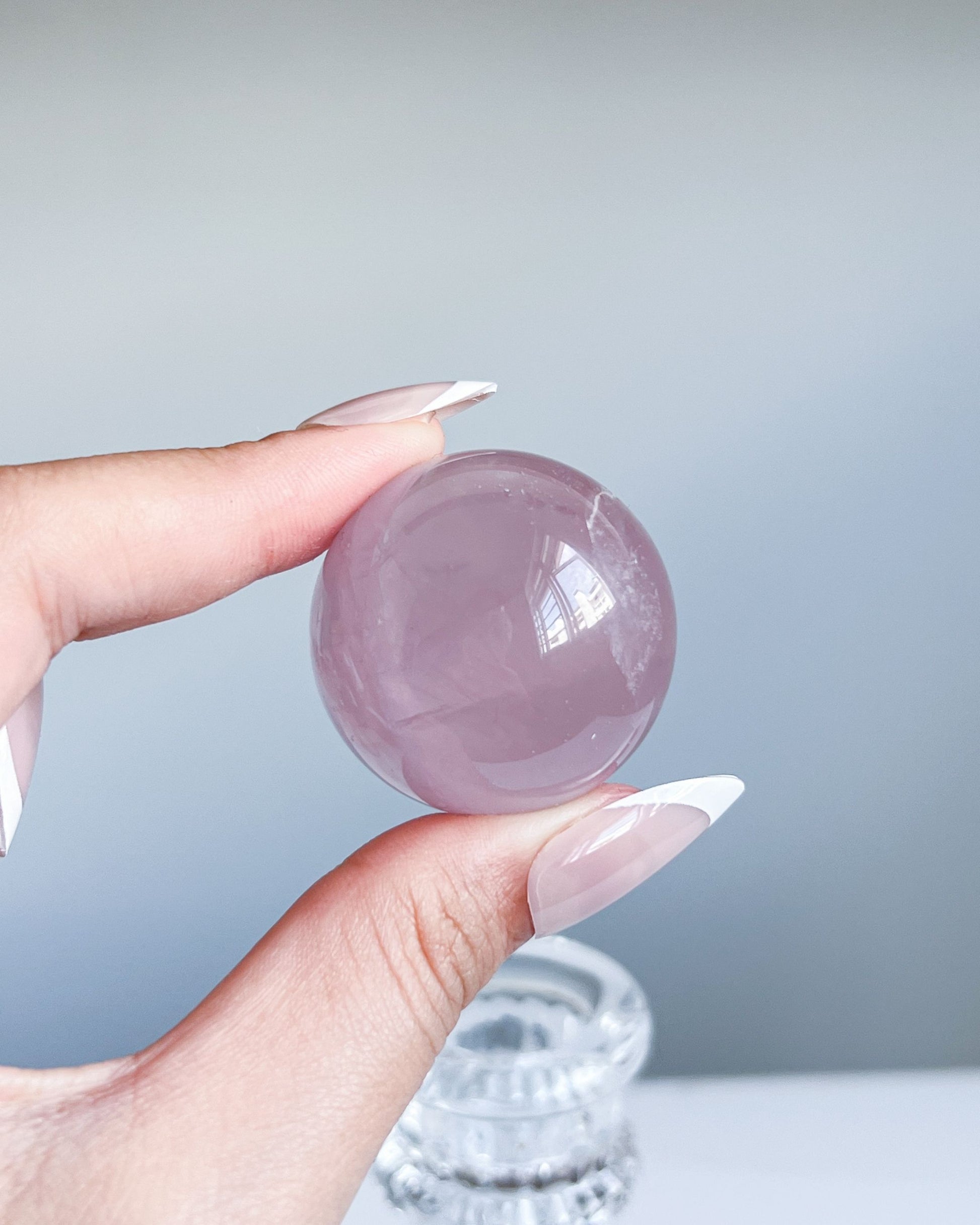 Close-up of Girasol Rose Quartz sphere G showing clear surface and side foggy quartz clouding