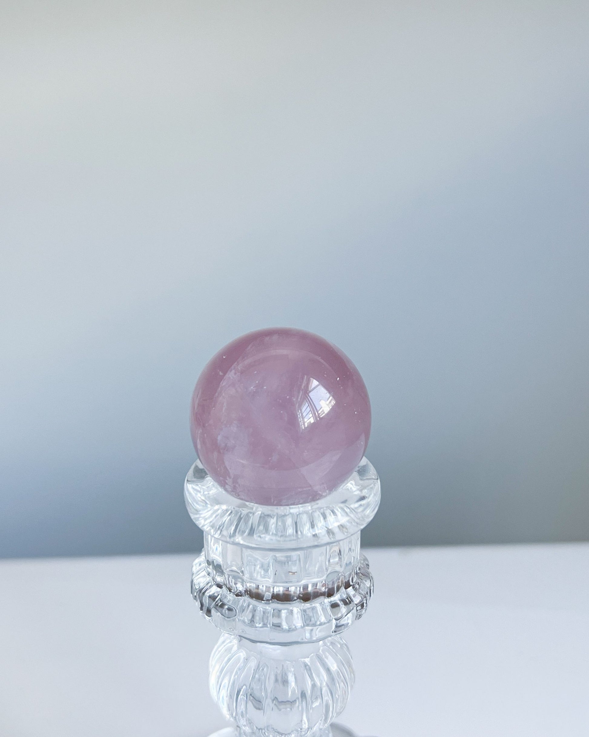 Girasol Rose Quartz sphere G styled on faceted glass stand against clean minimal background