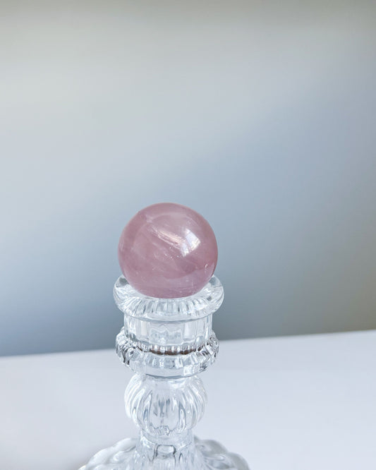 Girasol Rose Quartz Sphere H displayed on a crystal stand, showing deep pink tones and a glossy finish