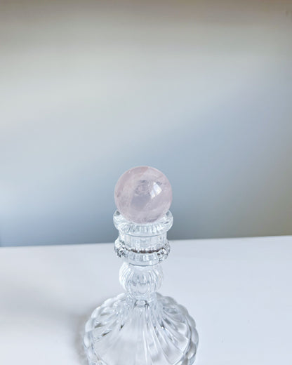 Girasol Rose Quartz Sphere I styled against a pale gradient backdrop, exuding ethereal elegance on pedestal