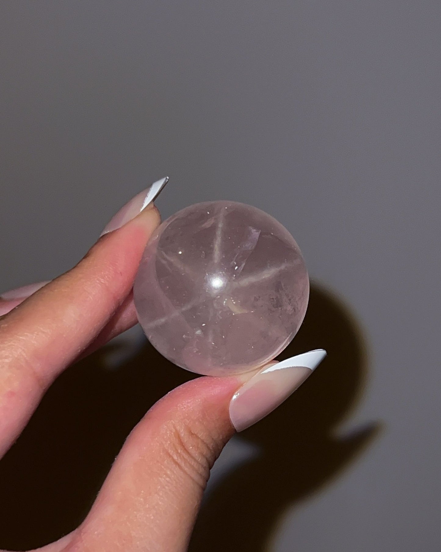 Girasol Rose Quartz sphere under flash revealing soft starburst reflections asterism