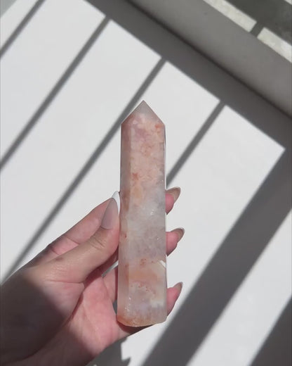 Video of hand holding a Carnelian Flower Agate tower with blush pink and translucent white patterns