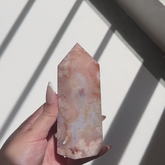 Video of Hand holding a pastel watercolour blue Carnelian Flower Agate tower