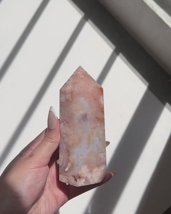 Video of Hand holding a pastel watercolour blue Carnelian Flower Agate tower