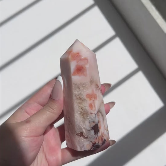 Video of Hand holding Carnelian Flower Agate tower with warm terracotta and cream banding
