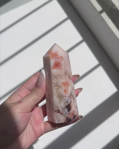 Video of Hand holding Carnelian Flower Agate tower with warm terracotta and cream banding