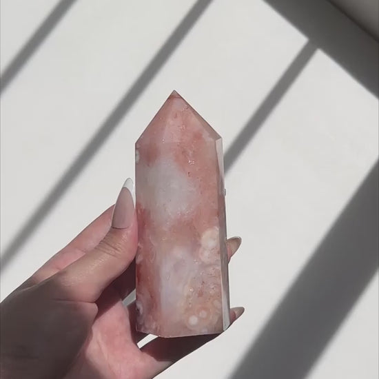 Video of Hand holding a pink Carnelian Flower Agate tower