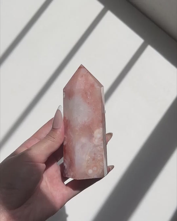 Video of Hand holding a pink Carnelian Flower Agate tower