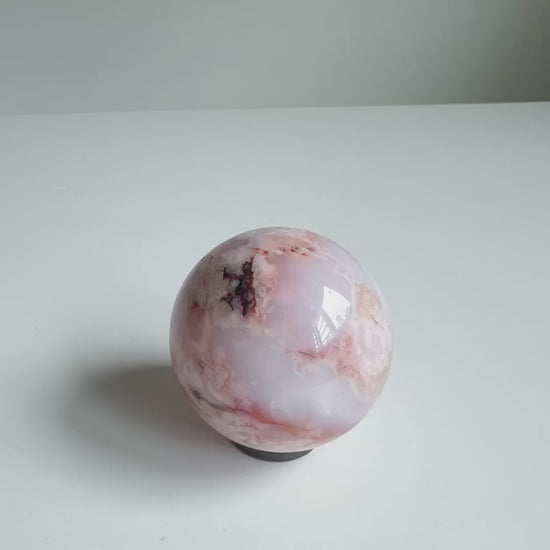 Video of a creamy blue and red toned Carnelian Flower Agate Sphere 46A